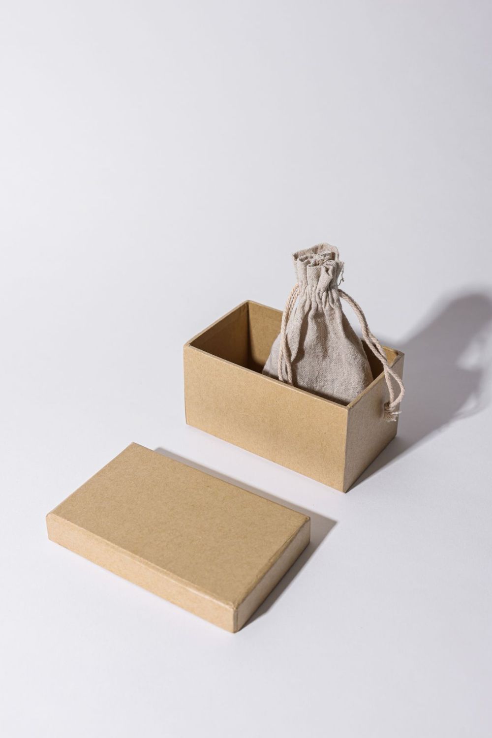 Boîte en carton ouverte contenant un petit sac en tissu
